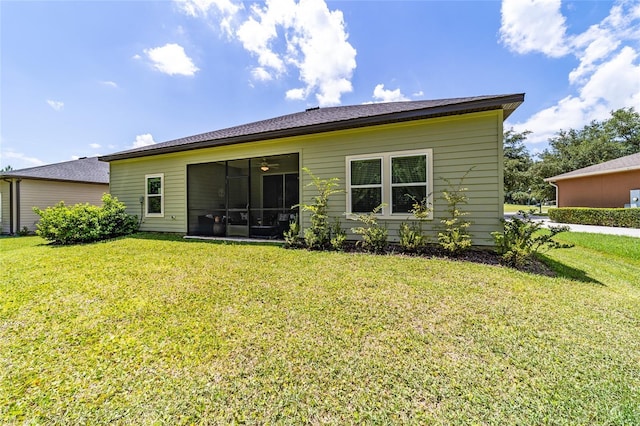 back of house featuring a sunroom and a lawn