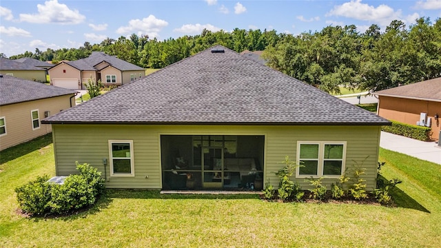 rear view of property with a yard and a sunroom