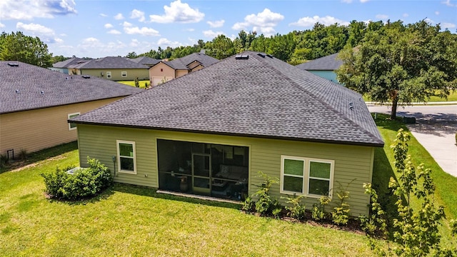 back of house with a lawn and a sunroom