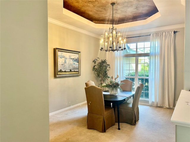 dining space featuring ornamental molding, a tray ceiling, light carpet, and baseboards