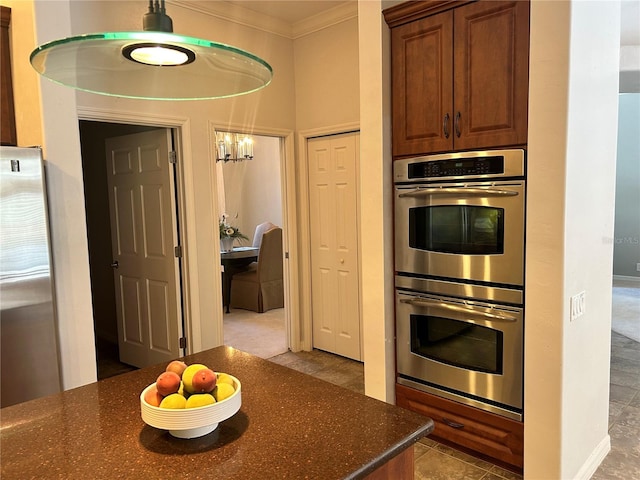 kitchen with stainless steel appliances, ornamental molding, and dark stone countertops