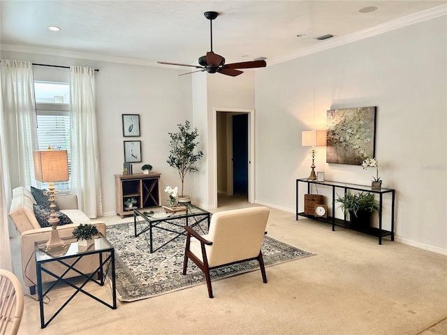 living room with a ceiling fan, visible vents, baseboards, ornamental molding, and carpet