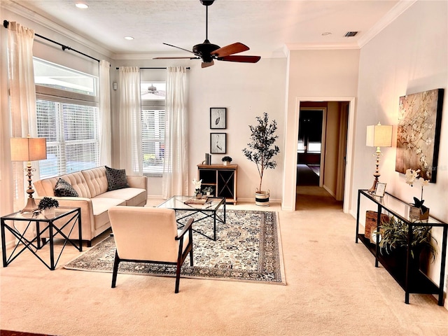 living room with ceiling fan, visible vents, baseboards, ornamental molding, and carpet