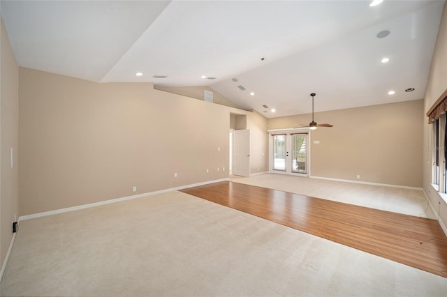 unfurnished room featuring lofted ceiling, light wood-style flooring, baseboards, and light colored carpet