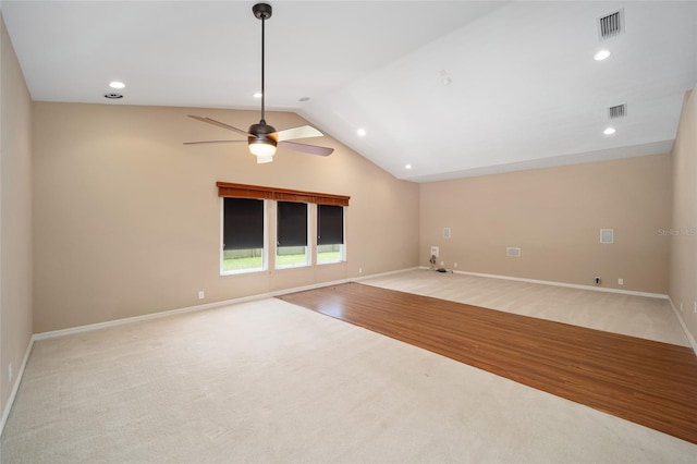 empty room with light wood finished floors, baseboards, visible vents, a ceiling fan, and vaulted ceiling