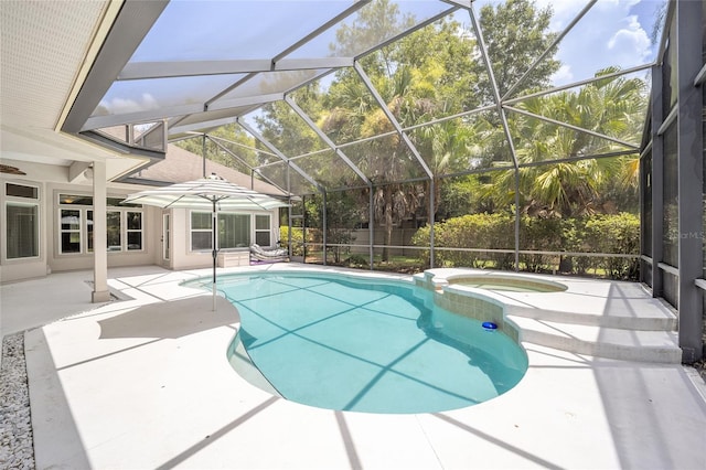 view of pool featuring a pool with connected hot tub, glass enclosure, and a patio