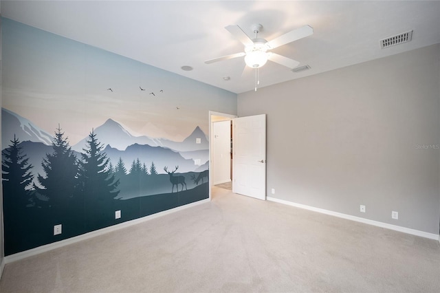 empty room featuring ceiling fan, carpet, visible vents, and baseboards