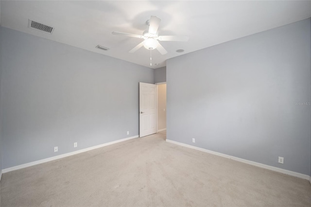 unfurnished room with light carpet, baseboards, visible vents, and ceiling fan