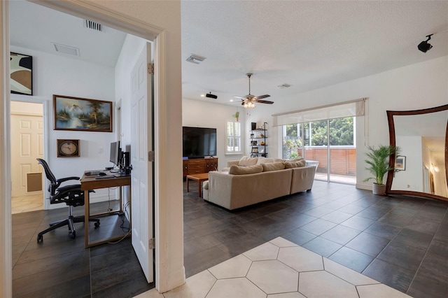 living room with ceiling fan and a textured ceiling