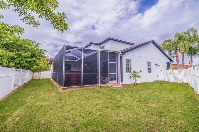 back of property featuring glass enclosure and a lawn