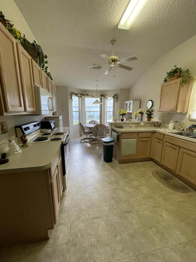 kitchen with lofted ceiling, white appliances, light tile patterned floors, ceiling fan, and sink