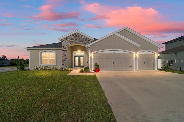 view of front of home with a garage and a lawn