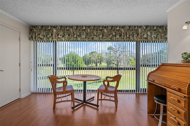 dining area featuring hardwood / wood-style floors, crown molding, and a textured ceiling