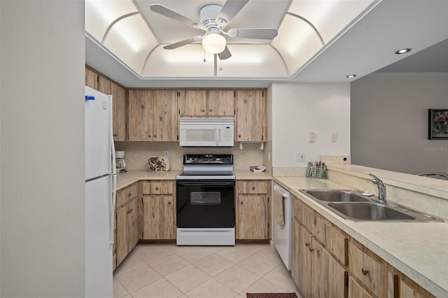 kitchen with sink, tasteful backsplash, light tile patterned floors, a tray ceiling, and white appliances