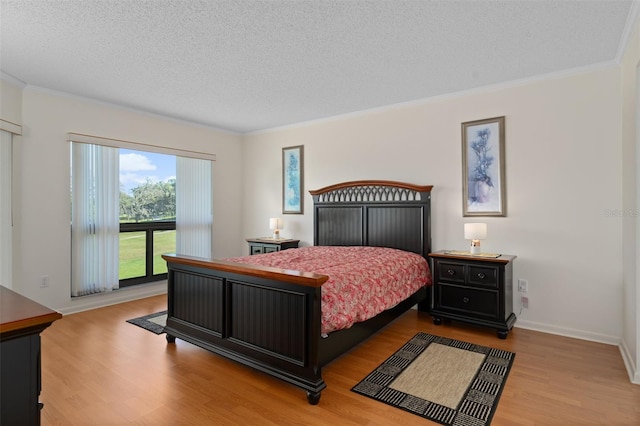 bedroom with a textured ceiling, crown molding, and light wood-type flooring