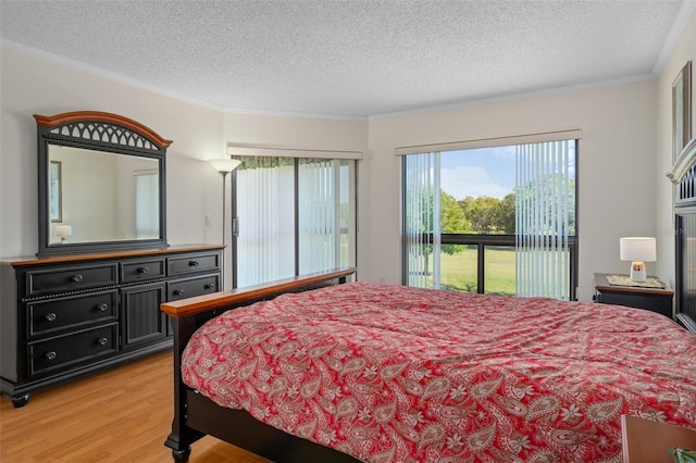 bedroom with light hardwood / wood-style floors, a textured ceiling, access to outside, and ornamental molding