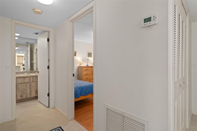 hallway with crown molding and light wood-type flooring