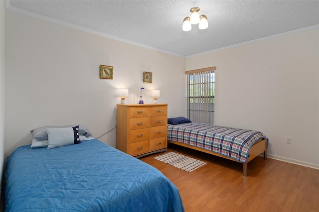 bedroom featuring a textured ceiling, hardwood / wood-style floors, and ornamental molding