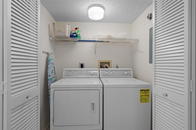 clothes washing area featuring washing machine and dryer and a textured ceiling