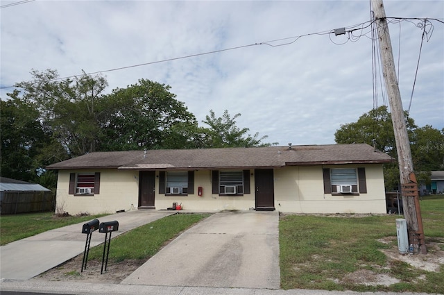 ranch-style home with a front lawn and cooling unit