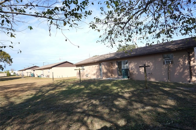 back of house featuring a yard and concrete block siding