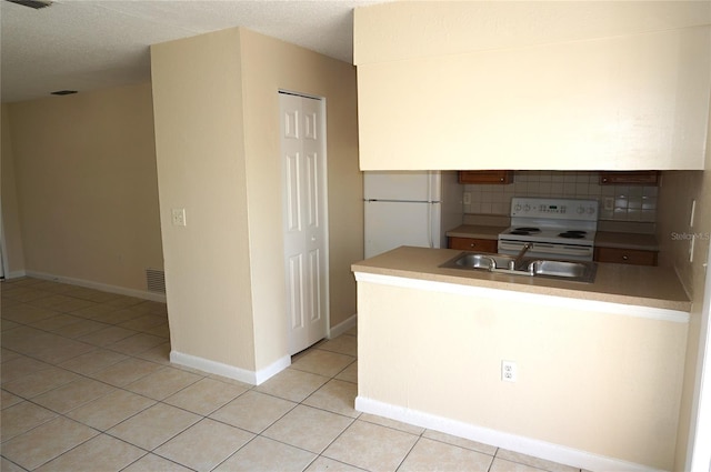 kitchen with visible vents, decorative backsplash, light tile patterned flooring, a sink, and white appliances