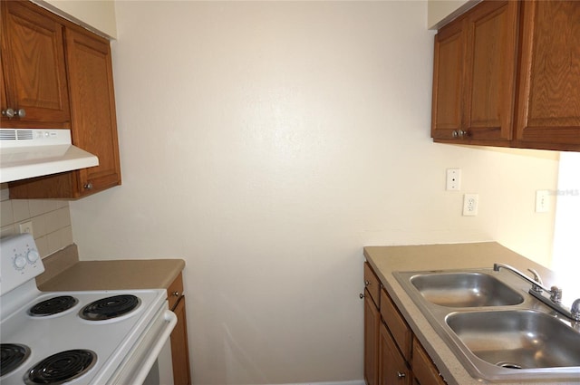 kitchen featuring electric stove, ventilation hood, brown cabinetry, and a sink