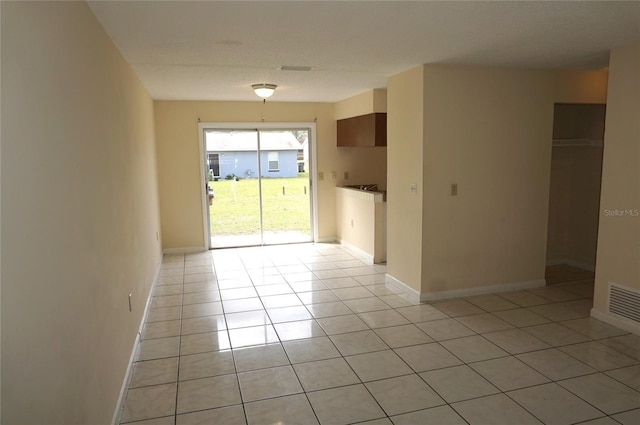 spare room featuring visible vents, baseboards, and light tile patterned floors