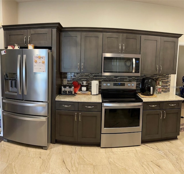 kitchen with appliances with stainless steel finishes, tasteful backsplash, and dark brown cabinetry