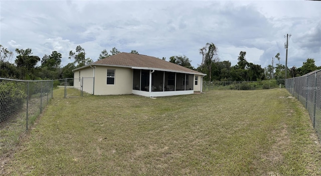 back of property with a sunroom, stucco siding, and a gate