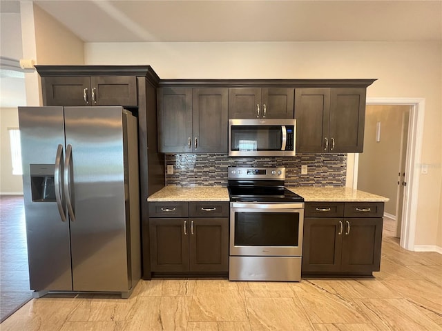 kitchen featuring appliances with stainless steel finishes, dark brown cabinetry, decorative backsplash, baseboards, and light stone counters