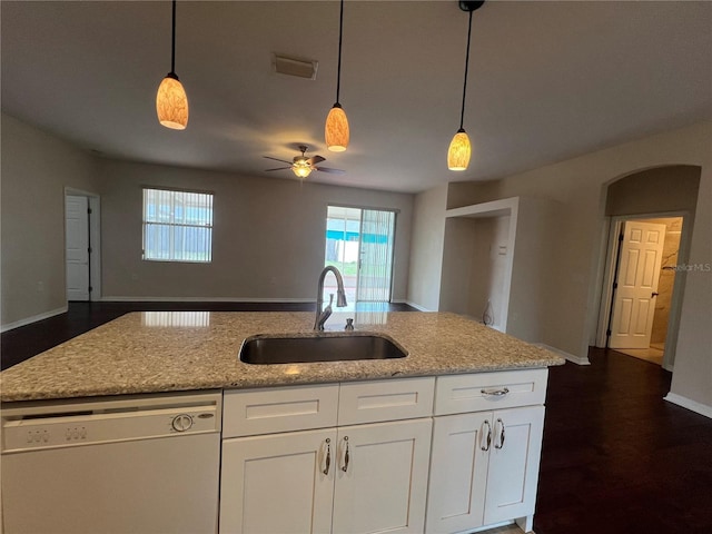 kitchen with dishwasher, a sink, open floor plan, a ceiling fan, and light stone countertops