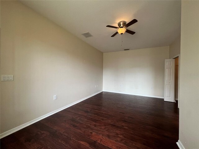 empty room with ceiling fan, dark wood-style floors, and baseboards