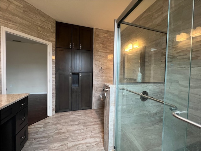 bathroom featuring a shower stall and vanity