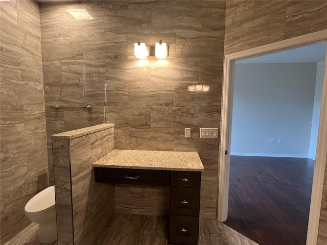 bathroom featuring toilet, wood finished floors, and vanity