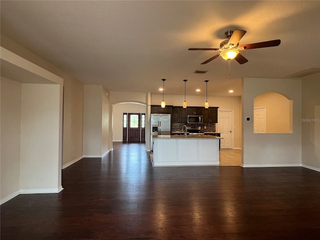 kitchen with arched walkways, stainless steel appliances, ceiling fan, open floor plan, and recessed lighting