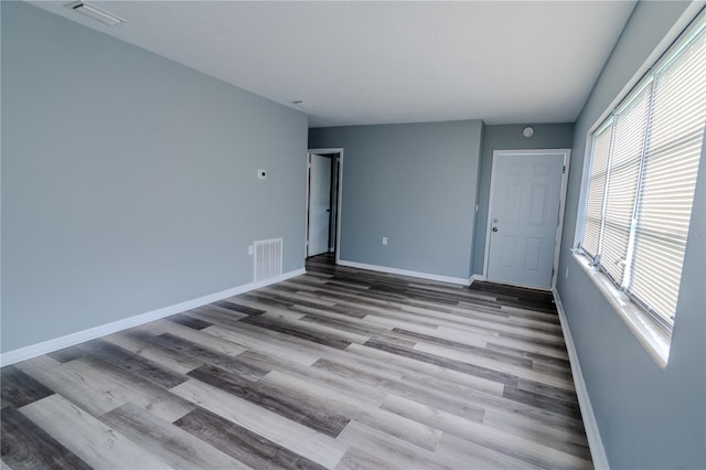 empty room featuring a wealth of natural light and light hardwood / wood-style floors