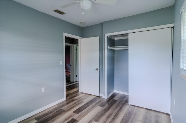 unfurnished bedroom with ceiling fan, wood-type flooring, and a closet