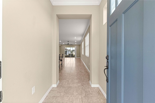 hall with light tile patterned floors and crown molding