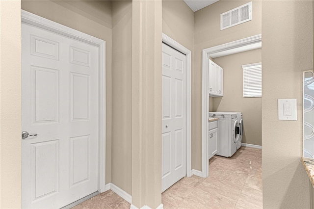 laundry room featuring cabinets and washer and clothes dryer