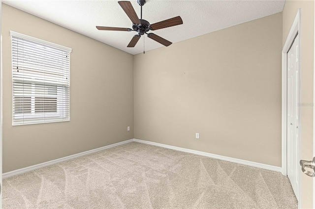 spare room featuring light carpet and ceiling fan