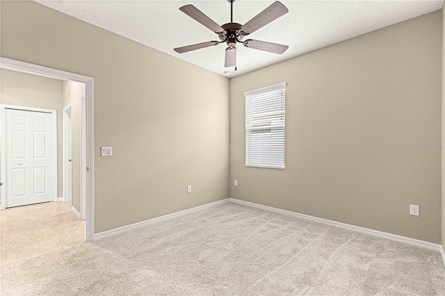 carpeted spare room featuring ceiling fan and a textured ceiling