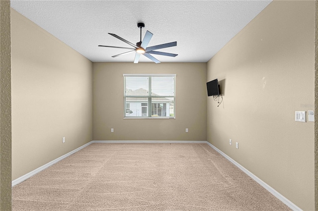 empty room with light carpet, a textured ceiling, and ceiling fan