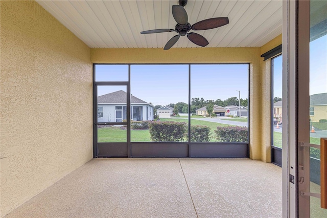 unfurnished sunroom featuring a wealth of natural light and ceiling fan