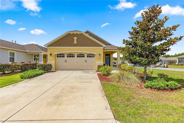 view of front facade featuring an attached garage, stucco siding, driveway, and a front lawn