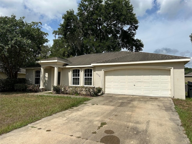 ranch-style house with a garage and a front lawn