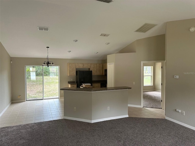 kitchen featuring light brown cabinetry, hanging light fixtures, black fridge, an inviting chandelier, and light colored carpet