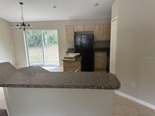 kitchen with range, an inviting chandelier, hanging light fixtures, light tile patterned floors, and black fridge