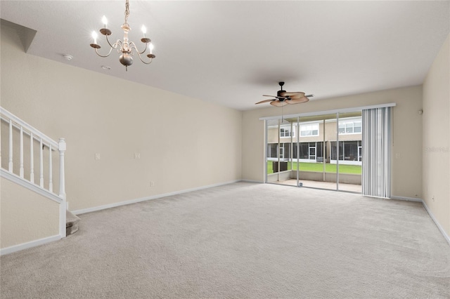 carpeted spare room with ceiling fan with notable chandelier