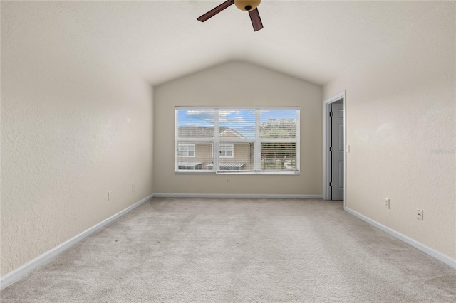 carpeted spare room with ceiling fan and lofted ceiling